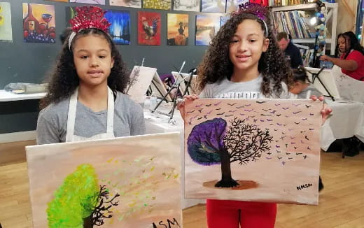 a couple of girls holding a drawing