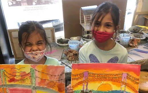 a couple of girls holding colorful paper crafts