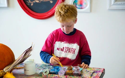 a boy painting on a table