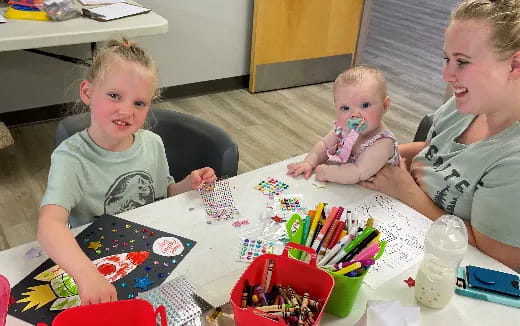 a group of kids sitting at a table with a cake