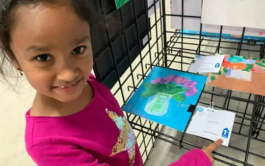 a girl holding a drawing