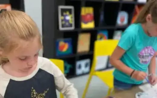 a young girl playing with a yellow toy