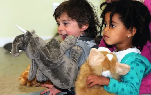 a couple of girls holding stuffed animals