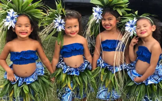 a group of girls in swimsuits sitting in the grass