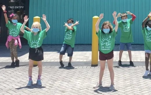 a group of children in green shirts