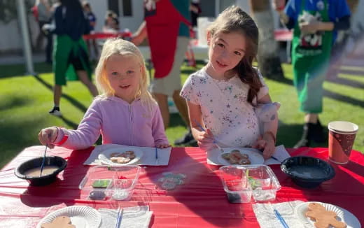 a couple of girls eating at a table
