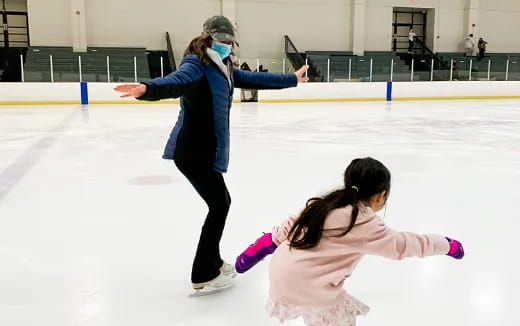 a woman and a girl ice skating