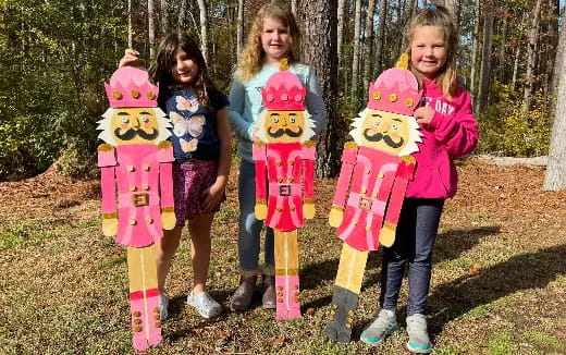 a group of girls holding up a large snowman