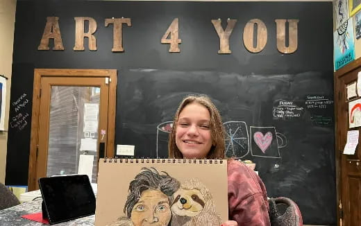 a person smiling in front of a laptop