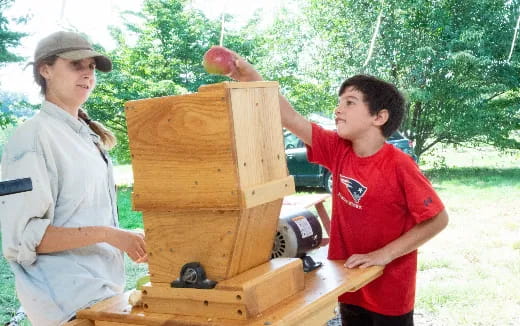 a man and a woman with a fruit on a wooden box