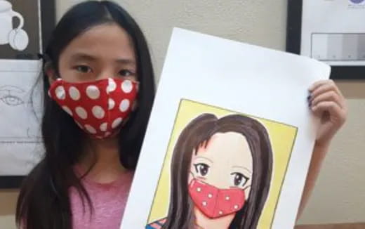 a girl holding a drawing