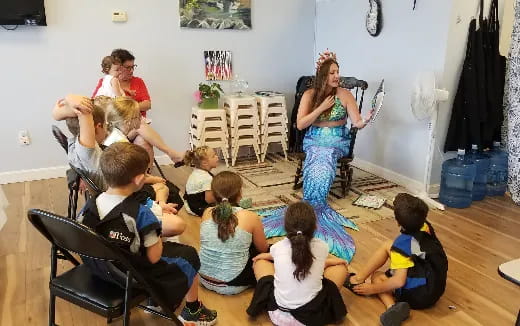 a group of children sitting on the floor in a room