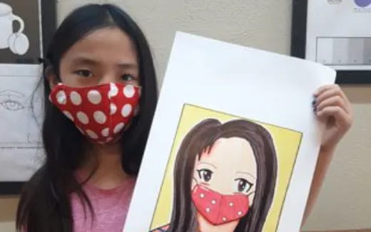 a girl holding a drawing