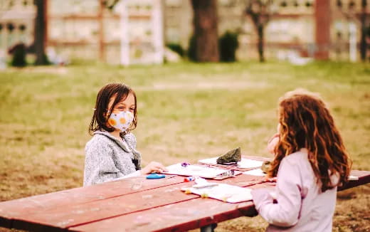 a couple of girls painting on a table