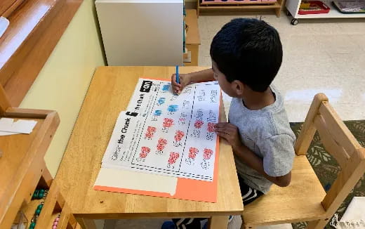 a child writing on a piece of paper
