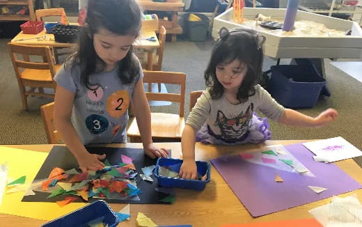 a couple of young girls playing with toys on a table