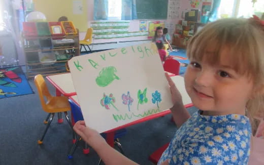 a child holding a drawing