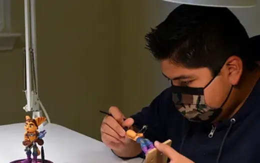 a man painting a doll