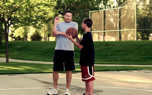 a person and a boy holding a basketball