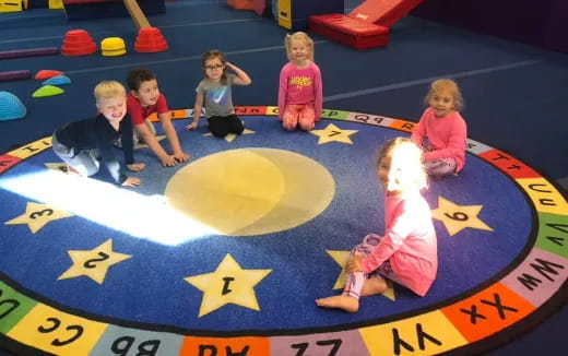 children sitting on a mat