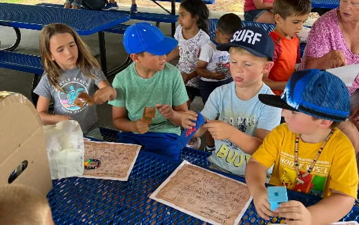 a group of children sitting at a table