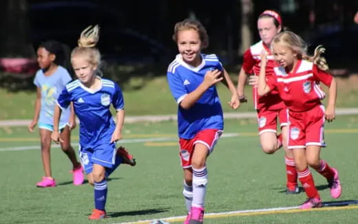 a group of girls running on a field