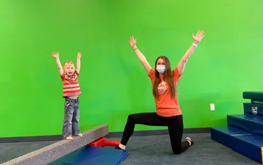 a woman and a child on a stage with their arms raised
