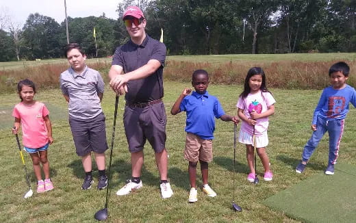 a group of kids standing on a grass field