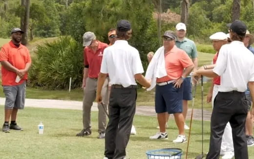 a group of people standing on a golf course