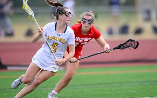 women playing lacrosse on a field