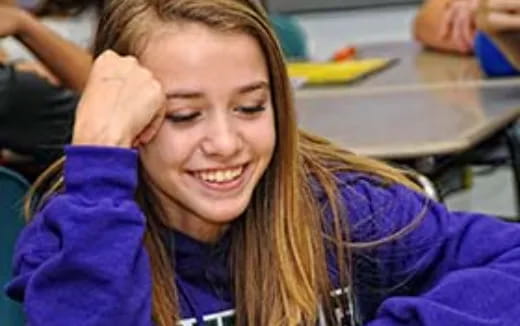 a woman smiling with her hand on her head