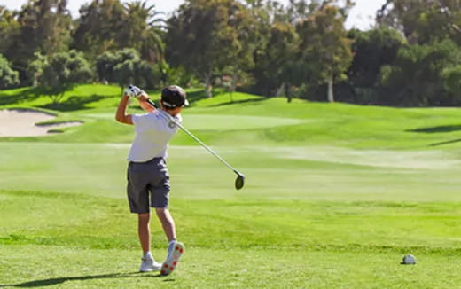 a person swinging a golf club