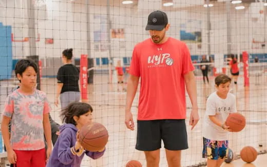 a person and kids playing basketball