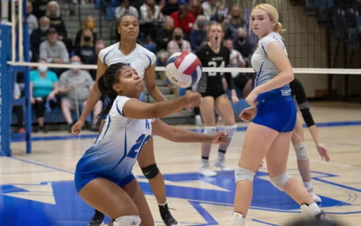 women playing volleyball in a gym