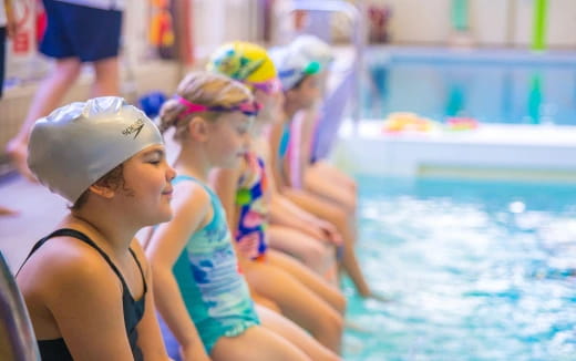 a group of women in swimsuits in a pool