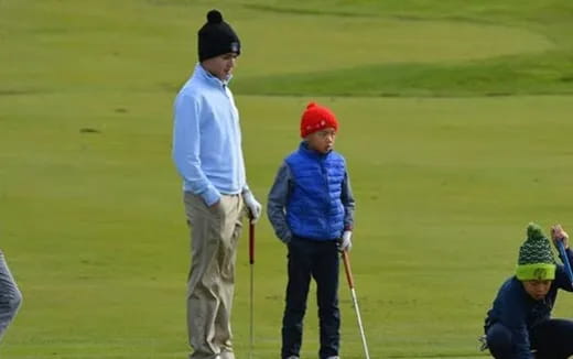 a man and a boy on a golf course