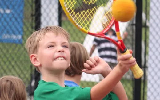 a kid playing tennis