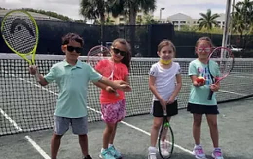 a group of kids holding tennis rackets