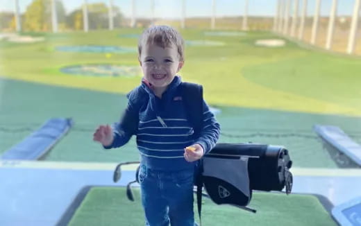 a boy holding a golf club