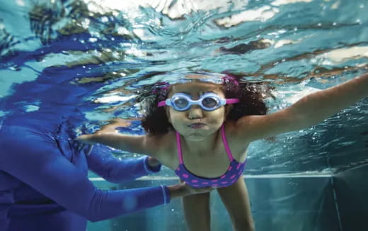 a woman wearing goggles and swimming