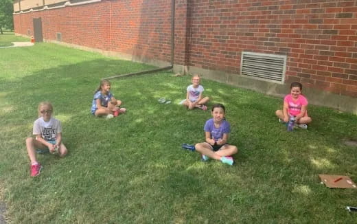 a group of kids sitting on the grass