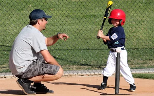 a person and a boy playing baseball