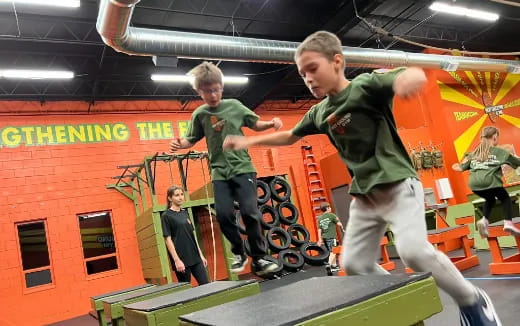 a couple of boys jumping on a trampoline