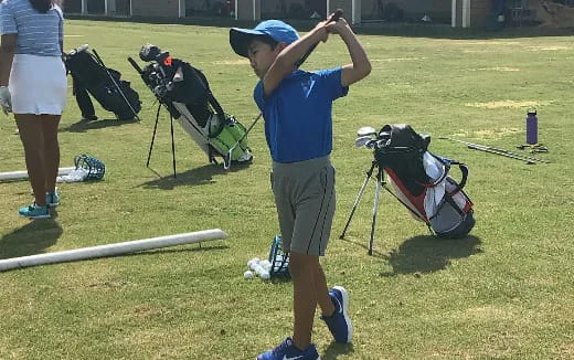 a woman swinging a golf club