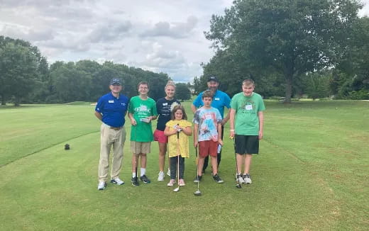 a group of people posing for a photo on a golf course