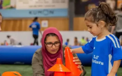 a person and a girl playing with toys on a field