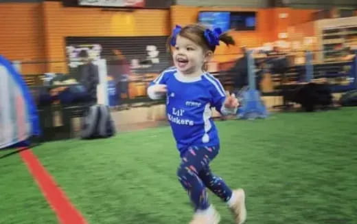 a young girl running on a field