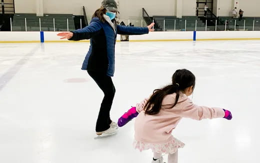 a woman and a girl ice skating