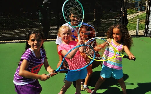 a group of girls holding tennis rackets