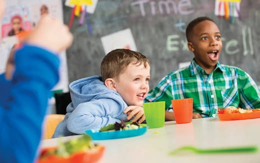 a few children eating at a table